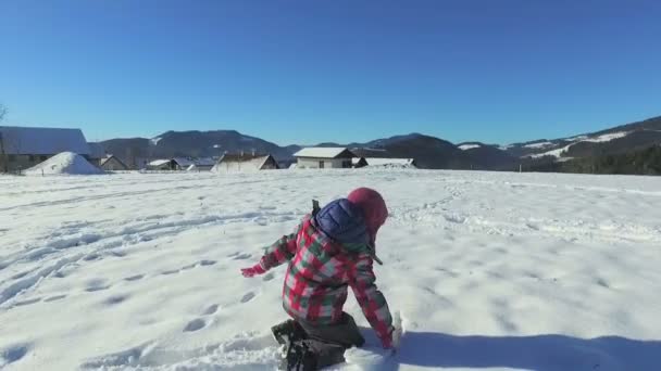 Девушка играет на снегу — стоковое видео