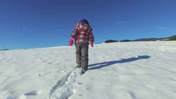 Niño caminando colina nevada — Vídeos de Stock