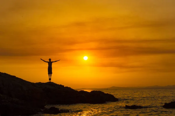 Ο άνθρωπος με τα χέρια υψωμένα στο ηλιοβασίλεμα — Φωτογραφία Αρχείου
