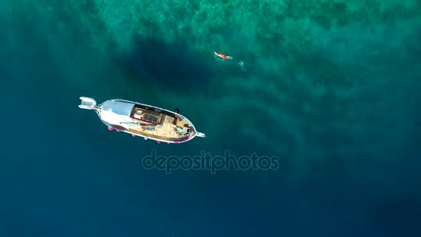 次にボートに海で泳ぐ人の空撮 — ストック動画