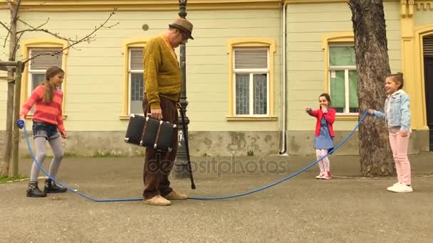 老男人跳跳绳与三女孩在街上 — 图库视频影像