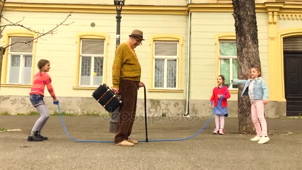 Oude Man Springen Een Springtouw Met Drie Meisjes Straat — Stockvideo