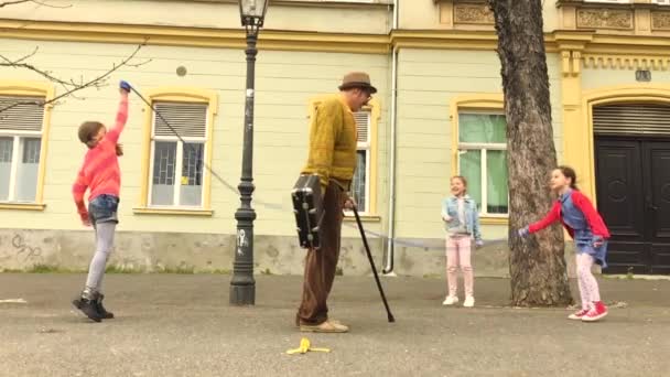 Oude Man Springen Een Springtouw Met Drie Meisjes Straat — Stockvideo