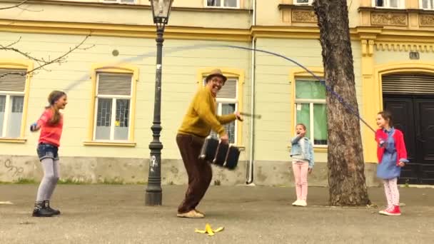 Старик Прыгает Скакалке Тремя Девушками Улице — стоковое видео