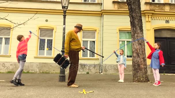 Yaşlı Adam Sokakta Kız Bir Atlama Atlama — Stok video