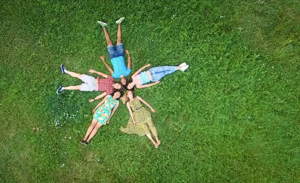 一群年轻的成年人躺在草地上 — 图库照片