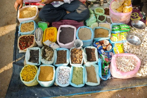 Street salesman sitting at spice stand. — Stock Photo, Image