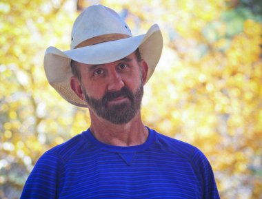 Kovboy sonbahar yaprakları ile bir orta yaşlı