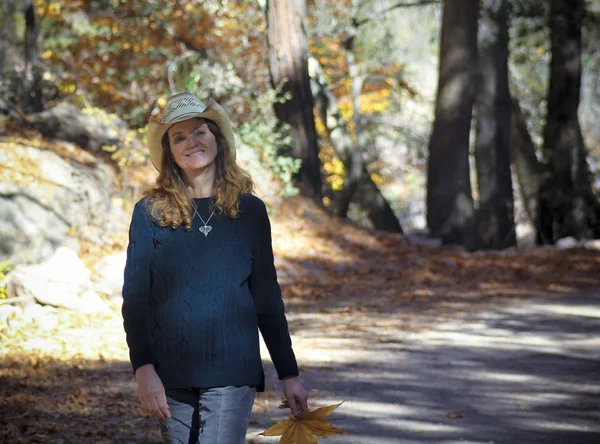 Cowgirl chodí lesní cesta na podzim — Stock fotografie
