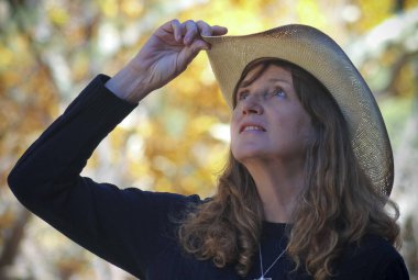 Bir Cowgirl arkasında sonbahar yaprakları ile