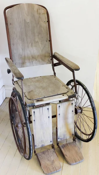 Uma cadeira de rolamento de madeira vintage, ou cadeira de rodas — Fotografia de Stock