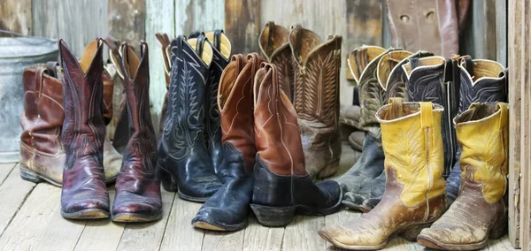 Un gruppo di dieci paia di vecchi stivali da cowboy — Foto Stock