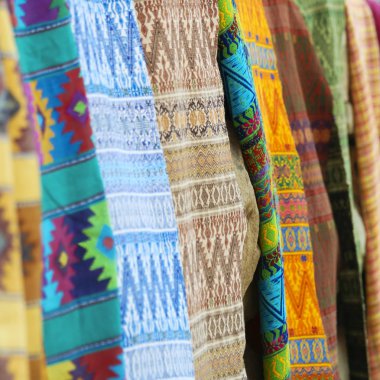 Bir ürün yelpazesine bir taş duvarda asılı renkli battaniye