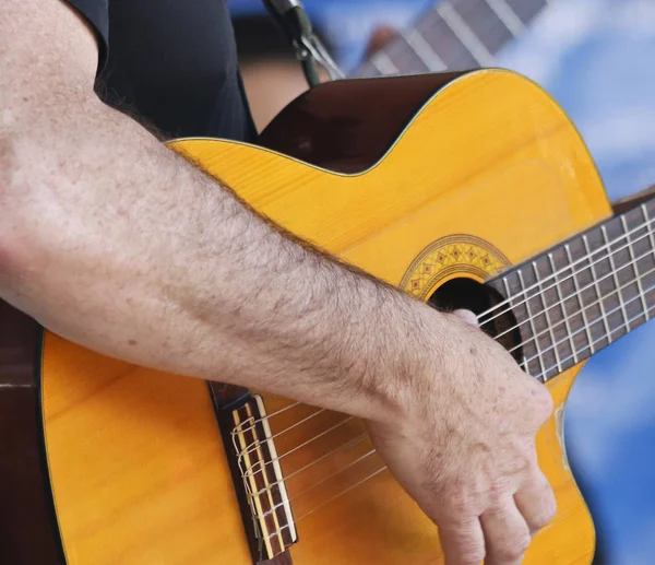 Un musicista suona una chitarra classica tagliata — Foto Stock