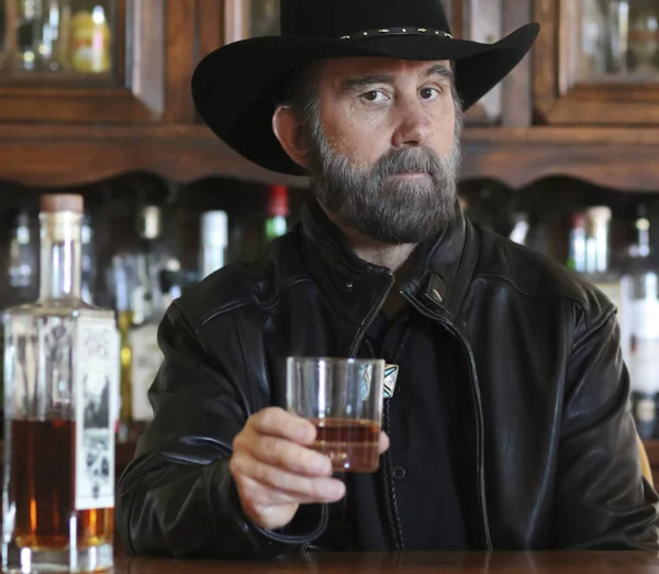 A Bearded Cowboy in Black Sitting Alone in a Saloon — Stock Photo, Image