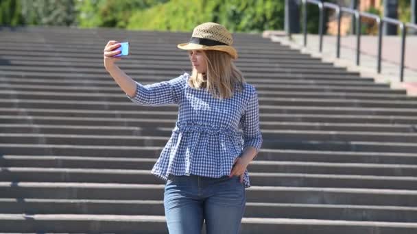 Chica bonita en un sombrero de paja en una escalera urbana — Vídeos de Stock