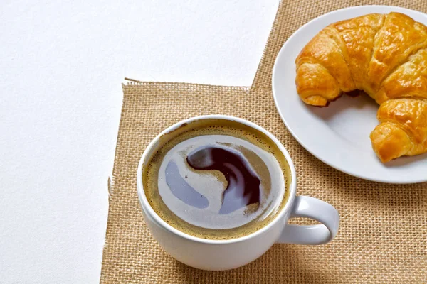 Kaffeetasse heiß und Croissant — Stockfoto