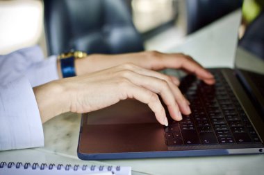 Çalışma ve içme kahve fincanı dizüstü bilgisayar kullanan kadın