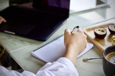 Çalışma ve içme kahve fincanı dizüstü bilgisayar kullanan kadın