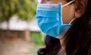 Yüzüne hijyen koruyucu bir maske takan Asyalı genç bir kadın. Sağlık ve hastalık önleme Coronavirüs, covid 19