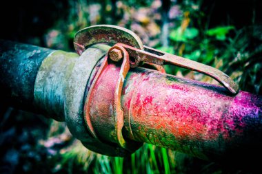 Bulanık çim ile karanlık bir arka plan üzerinde debriyaj ile eski renkli metal borular