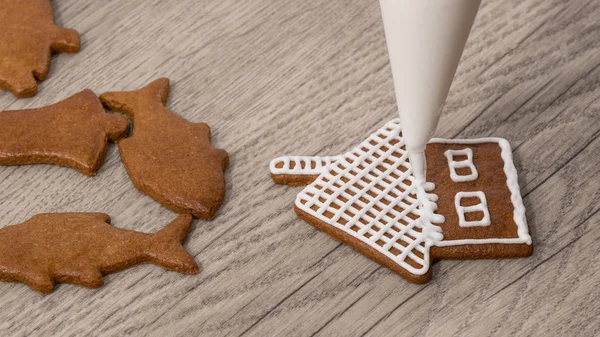 Close-up of decorating a christmas gingerbread in cottage shape — Stock Photo, Image
