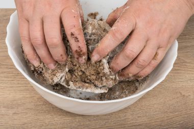 Beyaz kase kahverengi bir hamur yoğurma zaman eller Close-Up