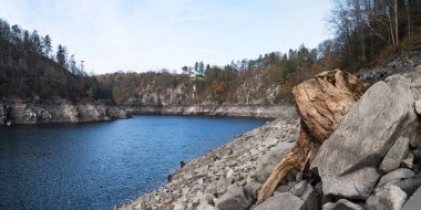 Mavi dalgalı su yüzeyi bir nehir yatağı dönüşünde. Sonbahar manzarasında kuraklık