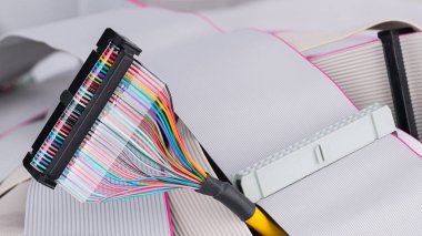 Colorful multi wire bus connector on white ribbon cables background clipart