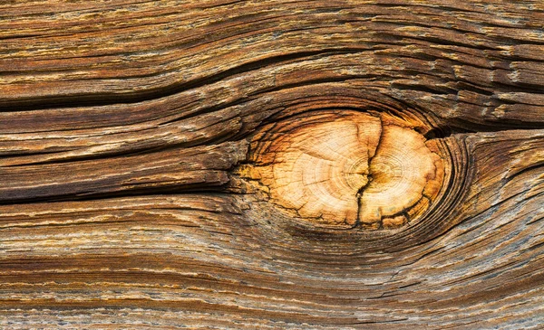 Bright natural wood knot detail in brown texture of aged cracked plank — 스톡 사진