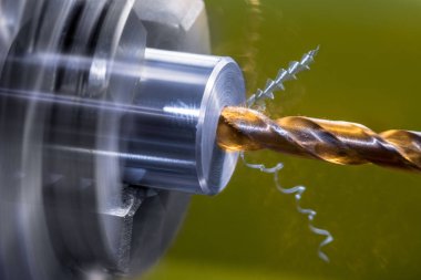 Torna tezgahını değiştiriyorum. Matkap ucunu vidala metal iş parçasında eksensel delik kes