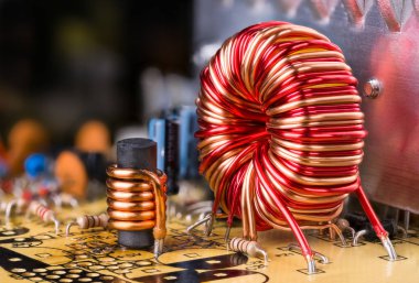 İndüktör bakır kablo sarma. Devre kartında lehimlenmiş elektronik bileşenler
