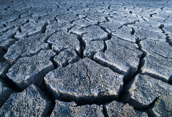 Suelo agrietado árido gris abstracto. Sequía en detalle textura del suelo — Foto de Stock