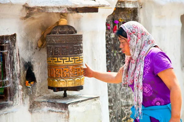 正体不明の女性がカトマンズ、ネパールで車輪を祈ってを回る. — ストック写真