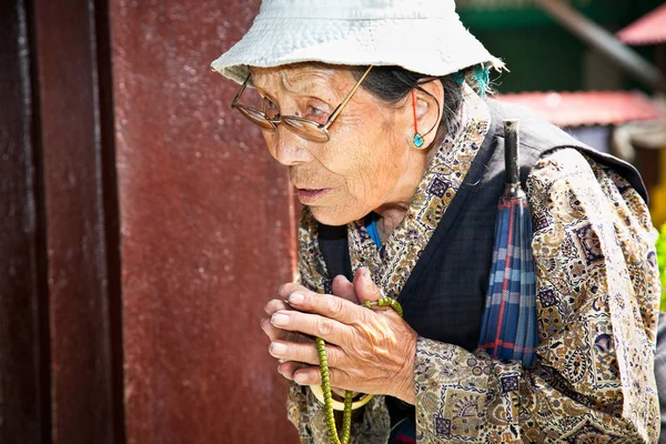 Donna non identificata con le sue perle di mala che prega a Bouddanath St — Foto Stock