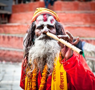 Katmandu,Nepal-18 Mayıs: Sadhu Katmandu Pashupatinath Tapınağı'nda flüt çalmak, Mayıs'ta Nepal 18, 2013. Sadhu topluluğundaki iki ana mezhepsel bölüm Shaiva sadhus ve Vaishnava sadhus'tur..