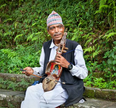 Pokhara - 22 Mayıs 2013 'te Pokhara, Nepal' de bir tür keman, geleneksel müzik enstrümanı çalan tanımlanamayan Nepalli. Zavallı Nepalliler turistlerden para kazanmak için oynuyorlar..