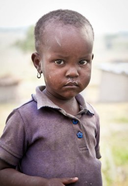 Afrika, Tanzanya-Şubat 9, 2014: portre üzerinde bir Afrikalı kız kameraya bakarak Masai kabilesi Köyü, inek gübresi, 9 Şubat 2014 ile yapılan evde yaşayan. Tanzanya.
