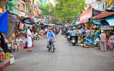 Ho Chi Minh City- 17 Kasım 2013: Ho Chi Minh City, Vietnam 'da sokak satıcısı ile kalabalık pazar kaldırımda ürün ve mal satışı (Ho Chi Minh City, Vietnam - 17 Kasım 2013)