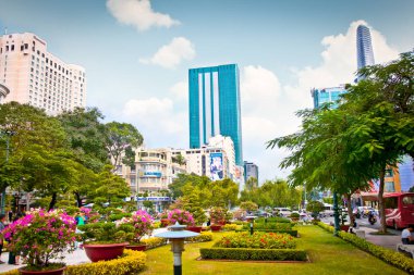 Saigon, Vietnam-Nov 18 Kasım 2013: Ho Chi Minh City 'nin veya Saigon' un merkezine park. Yeni modern cam bina Vietnam kültür ve teknolojisinin dinamik ilerlemesini gösteriyor..