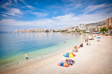 Saranda, Arnavutluk - 08 Haziran 2014: Pablic plajında kimliği belirsiz turistler 08 Haziran 2014 tarihinde Arnavutluk 'un Saranda kentinde. Saranda, Arnavutluk 'un en önemli ve en popüler tatil beldelerinden biri..