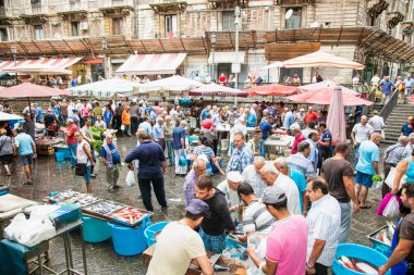 Catania, İtalya - 17 Eylül 2014: 17 Eylül 2014 tarihinde Catania 'daki ünlü balık pazarında satıcı ve byers. Bu pazar aynı zamanda Catania, Sicilya 'da turistik ilgi odağı..