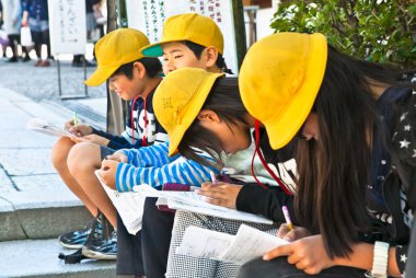 Kyoto, Japonya-24 Ekim 2014: Sarı şapkalı Japon okul çocukları 24 Ekim 2014 'te Kyoto Caddesi' nde ödev yaptılar..