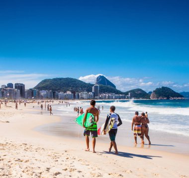 Rio De Janeiro, Brezilya - 24 Nisan 2015: Sörfçüler 24 Nisan 2015 tarihinde Copacabana Beach, Rio de Janeiro'da sörf tahtalarını taşıyorlar. Brezilya.