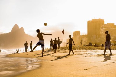 Rio De Janeiro, Brezilya - Nisan 24, 2015: Carioca Brezilyalılar Nisan'da gün batımı Ipanema Beach futbol topları tekme altınho futebol plaj futbolu oynarken 24, 2015, Rio de Janeiro. Brezilya.