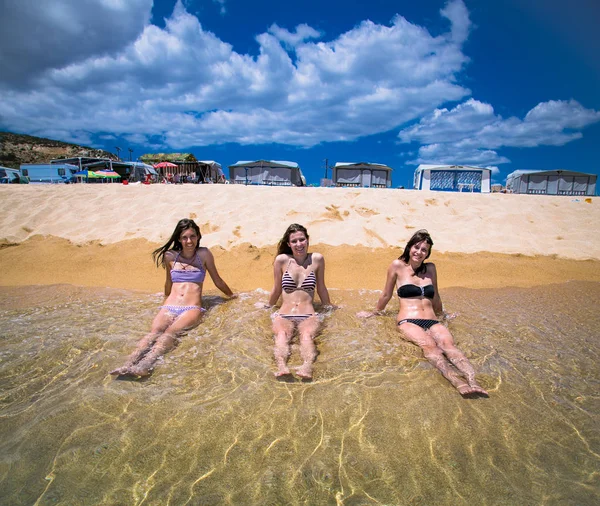 ビーチでファンを持つ3人の美しい魅力的な若い女性 — ストック写真