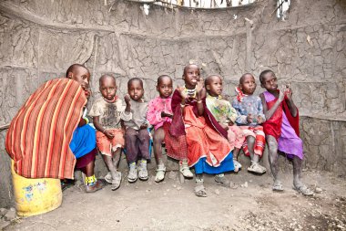 Afrika, Tanzanya-Şubat 9, 2014: portre inek gübresi, 9 Şubat 2014 ile yapılan anaokulu oynayan kameraya gülümseyen bir Afrikalı çocuklar Masai kabilesi köyüne. Tanzanya.