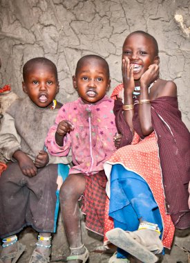Afrika, Tanzanya-Şubat 9, 2014: portre kameraya gülümseyen bir Afrikalı çocuklar Masai kabilesi köyüne, inek gübresi, 9 Şubat 2014 ile yapılan evde yaşayan. Tanzanya.