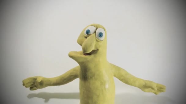 animation stop motion d'un drôle de personnage de plasticine jaune fléchissant ses biceps . 