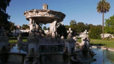 İtalya, Roma 'daki Villa Doria Pamphili Halk Parkı' ndaki Aşk Çeşmesi 'nin dış perdede sırayla iki erkek ve iki dişi perinin bulunduğu dört sütun tarafından desteklenen dairesel bir havza.